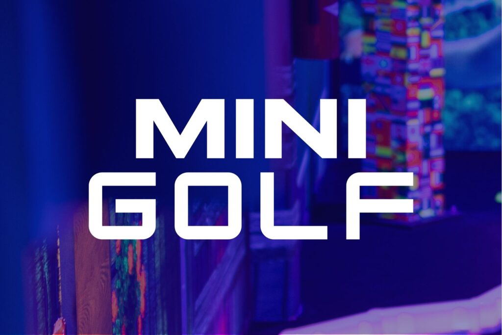 Mini golf course at The Rush Funplex, featuring colorful obstacles and players enjoying a sunny day outdoors.