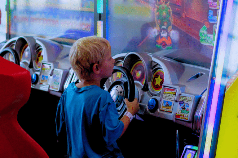 A young boy plays a game machine at The Rush Funplex arcade, focused and enjoying the vibrant atmosphere.