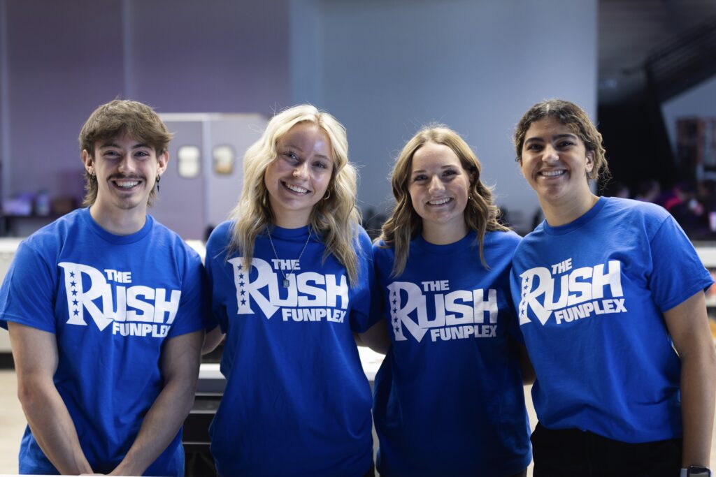 The Rush team poses together at The Rush Funplex during the Rush Conference, showcasing their enthusiasm and collaboration.