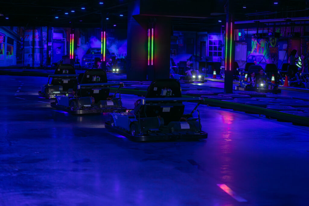 A room at The Rush Funplex illuminated by purple lights, featuring a wall with a door.